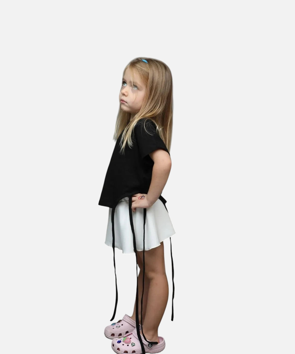 Nounami girls black short sleeve top and white flared skirt set with ribbon tie detail worn by a young girl
