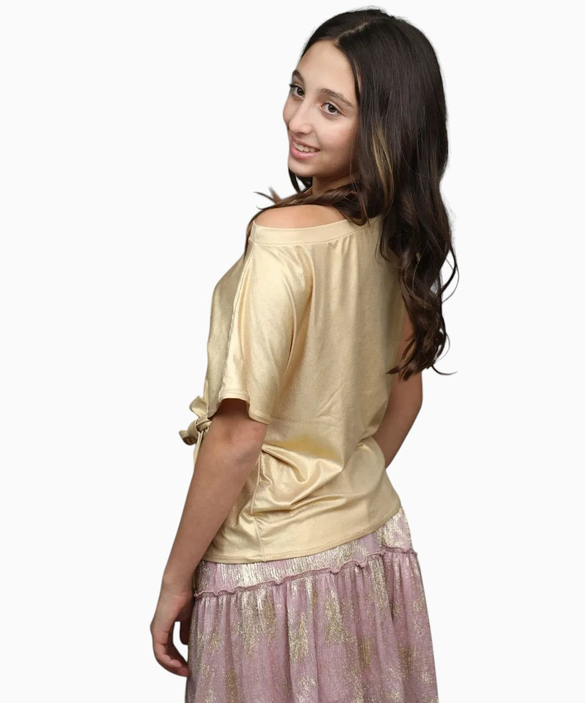 Nounami metallic gold off-the-shoulder top with side-tie paired with a dusty rose tiered skirt on a young woman